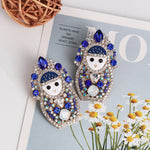 Boucles d'oreilles matriochka avec diamants bleus.